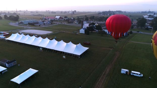 Aerial View of Sunrise with Hot air Balloons Taking Off with Glow as Seen by a Drone