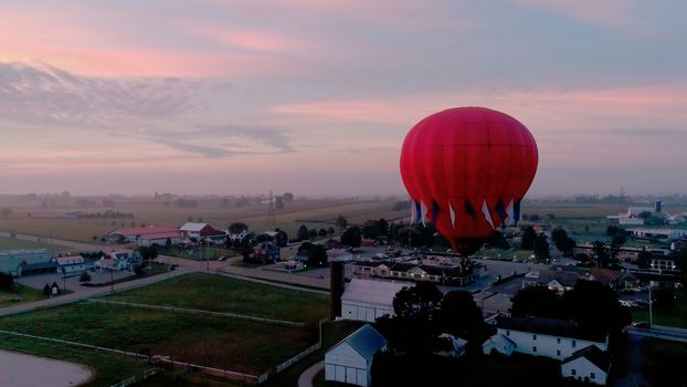 Aerial View of Sunrise with Hot air Balloons Taking Off with Glow as Seen by a Drone