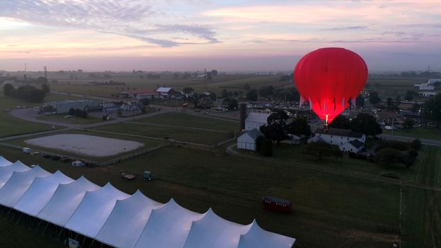 Aerial View of Sunrise with Hot air Balloons Taking Off with Glow as Seen by a Drone