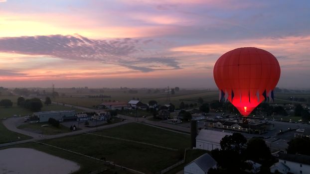 Aerial View of Sunrise with Hot air Balloons Taking Off with Glow as Seen by a Drone