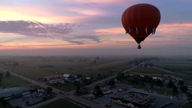 Aerial View of Sunrise with Hot air Balloons Taking Off with Glow as Seen by a Drone