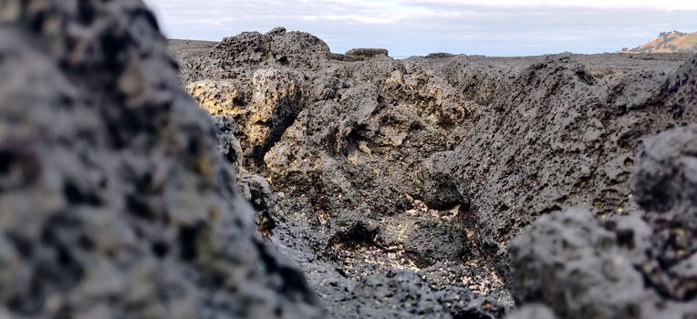 Macro shot of volcanic black rock and sky on the hyeopjae beach while in vacation in jeju island, south korea