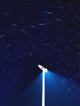 Star tracks around outdoor lantern, Kemer, Turkey. Long exposure of starry night sky.