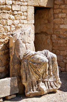 Ancient statue in Dougga, Roman Ruins: A Unesco World Heritage Site in Tunisia. Ruins of the roman City of Dougga with the Capitol.