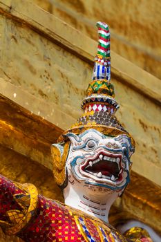 Sculpture in Royal Palace, Bangkok, Thailand. Wat Phra Keo. Architecture detail - face of mythical creature in mosaic hat.