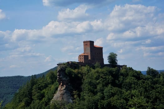 Medieval Trifels castle on mountain top with clouds and blue sky