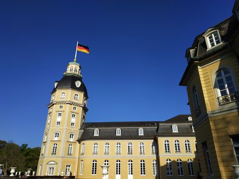German flag above Karlsruhe castle in front of clear blue sky