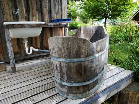 A sink and a wooden vintage bathtub in the garden