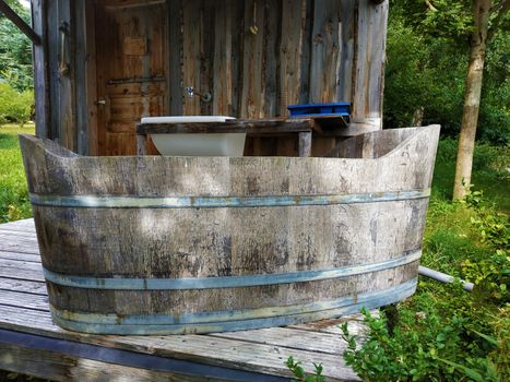 An exterior bathroom with a wooden tub on the terrace