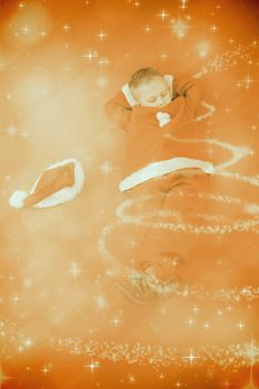 Little boy napping in santa costume against glittering christmas tree design