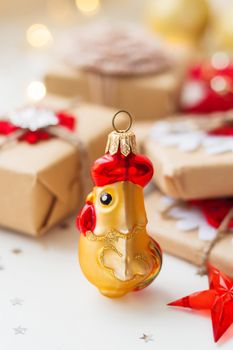 Christmas and New Year background with rooster, symbol of 2017 year, presents and decorations for Christmas tree. Holiday background with stars confetti and light bulbs. Place for text.