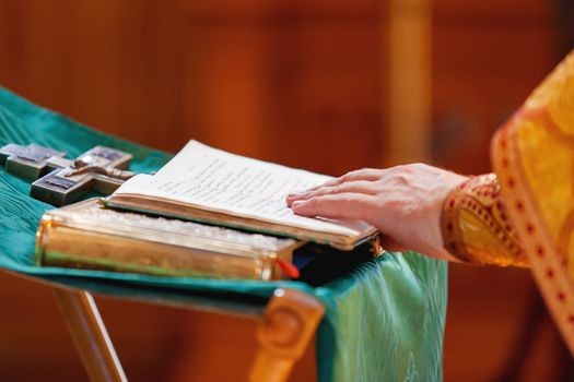 Prayer book in the hands of the priest. Ceremony in the Orthodox Christian Church. Russia. Selective focus.