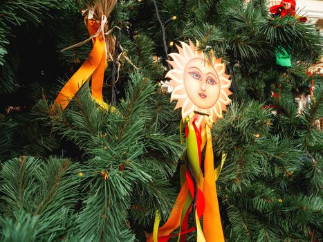 Maslenitsa celebration. Fir tree decorated with sun symbols and colorful ribbons. Moscow, Russia.
