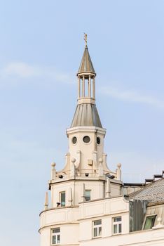 Decorative turret with weather vane on the roof of a modern building. Architectural detail.