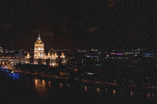 Hotel Ukraine, landmark near historic center of Moscow. Cityscape in snowy winter evening. Panoram view on city at night.