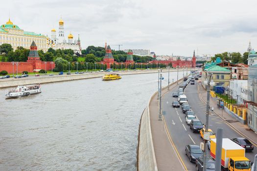 Traffic on Sofiyskaya embankment in Moscow. Main landmark - Kremlin on Moscow-river. Russia.