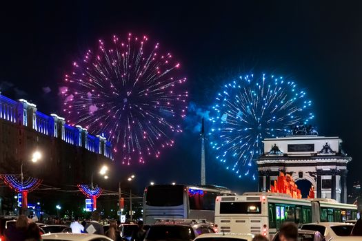 Fireworks near the Triumphal Arch and Historical Museum of Second World War on Poklonnaya hill in Victory day, May 9, 2015. Road traffic, car stops, drivers watchs fireworks in night sky. Moscow, Russia.