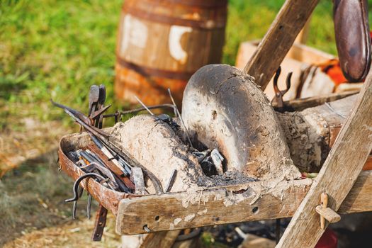 Iron old fashioned tools on portable forge. Old furnace and bellows. Historical reconstruction of 19 century.