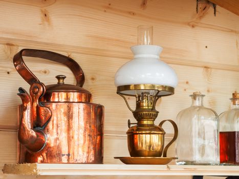 Vintage household items - copper teapot, table lamp, glass bottles with stoppers.