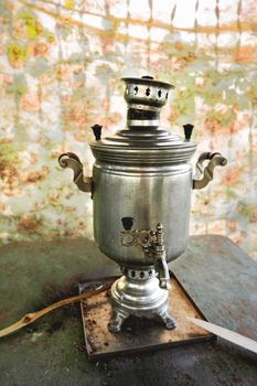 Brass samovar, tin-plated. Vintage Russian device to heat water by firewood for beverages. Old fashioned, antique metal kettle. Rustic background.