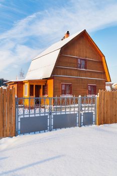 Cottage settlement. Street of wooden country houses. Winter sunny day. Russia.