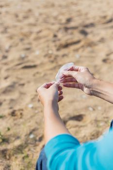 Woman holds a white feather of a seagull in hand. Symbol of lightness and fragility.