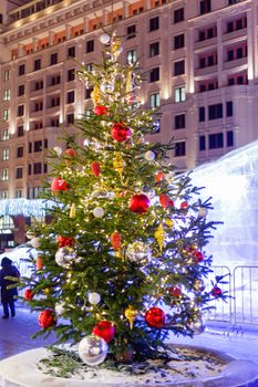 Streets in the historical center of Moscow decorated for New Year and Christmas celebration. Fir trees with bright red and yellow balls and light bulbs. Russia.