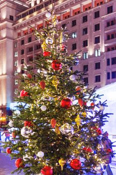 Streets in the historical center of Moscow decorated for New Year and Christmas celebration. Fir trees with bright red and yellow balls and light bulbs. Russia.