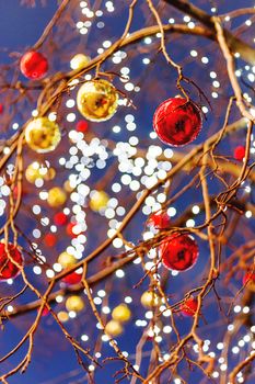 Streets of Moscow decorated for New Year and Christmas celebration. Tree with bright red and yellow balls. Russia.
