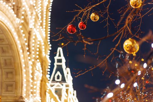Streets of Moscow decorated for New Year and Christmas celebration. Tree with bright red and yellow balls. GUM (Main Department Store) building with light bulbs. Russia.