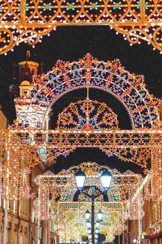 Streets of Moscow decorated for New Year and Christmas celebration. Buildings with light bulbs. Russia.