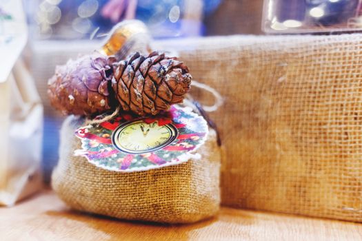 Christmas and New Year decoration - little bag made of burlap with pine cones and drawn clocks and wreath. Hand made present. Winter holiday gift.