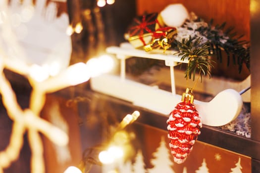 Christmas and New Year decorations - white wooden sledge with bright sparkling pine cone and fir tree branches.