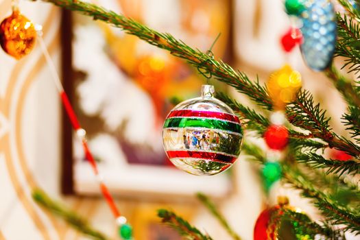 Fir tree decorated with shiny old fashioned balls and light bulbs for Christmas and New Year celebration.
