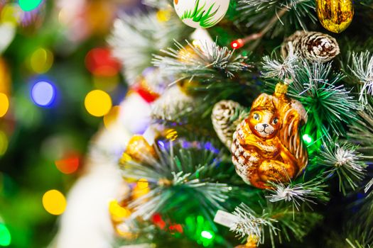 Fir tree decorated with shiny old fashioned toys and light bulbs for Christmas and New Year celebration.