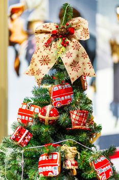 Fir tree decorated with gingerbread in shape of double decker bus and fabric balls for Christmas and New Year celebration.