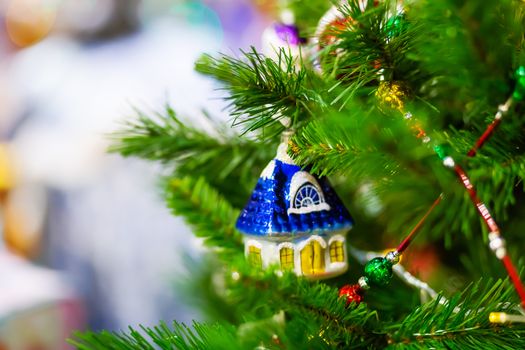 Fir tree decorated with shiny old fashioned toys and light bulbs for Christmas and New Year celebration.