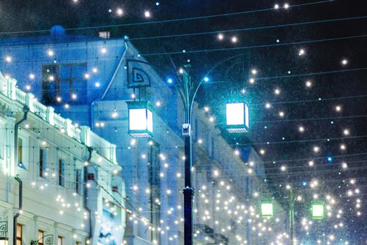 Blizzard rages around street lantern. Strong wind and snow on streets of Moscow, decorated to celebrate the New year and Christmas. Russia.