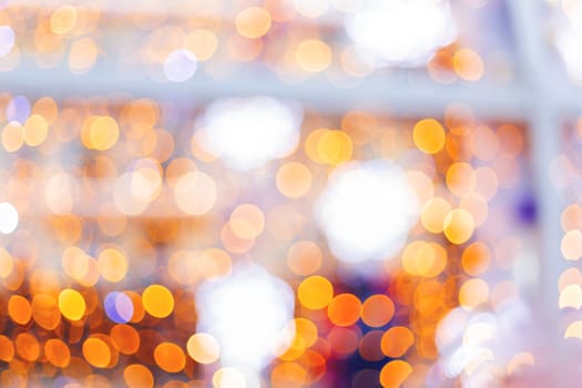 Defocused night street lights, blurred colorful bokeh background. Holiday colorful lanterns and light bulbs garlands.