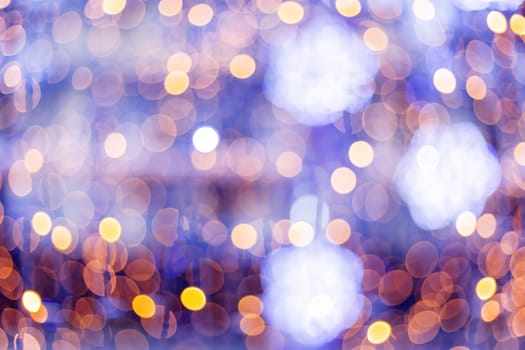Defocused night street lights, blurred colorful bokeh background. Holiday colorful lanterns and light bulbs garlands.