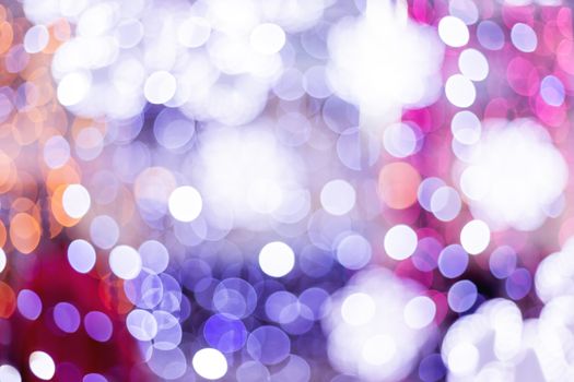 Defocused night street lights, blurred colorful bokeh background. Holiday colorful lanterns and light bulbs garlands.