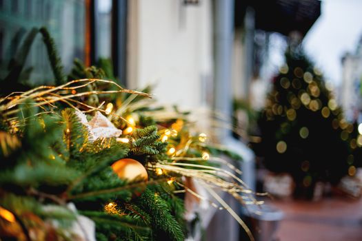 Christmas and New Year outdoor decorations - traditional fir tree wreaths with light bulbs, pine cones and balls.