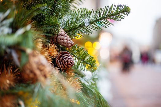 Christmas and New Year outdoor decorations - traditional fir tree wreaths with light bulbs, pine cones and balls.