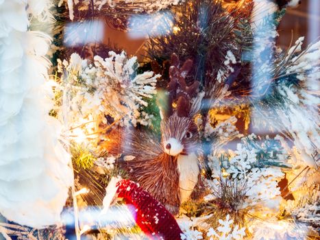 Christmas and New Year decorations with deer made of straw, light bulbs and fake snow.