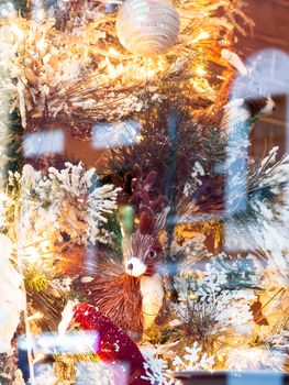 Christmas and New Year decorations with deer made of straw, light bulbs and fake snow.