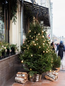 Streets of Moscow decorated for New Year and Christmas celebration. Fir trees with golden balls and light bulbs. Russia.