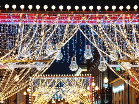 Streets of Moscow decorated for New Year and Christmas celebration. Arch with decorative transparent light bulbs. Russia.
