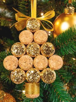 Christmas tree symbol made of corks of used wine bottles and spangles. Creative decoration for New Year celebration.