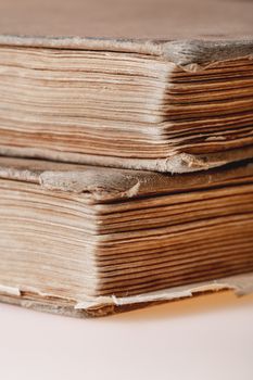 Two old books. Books with shabby covers and ragged pages on light pink background.