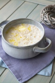 Milk soup with noodles and dough in a ceramic bowl, vertical